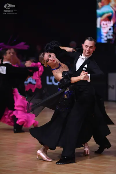 Dancesport competitor: Male dancer (foreground): black tuxedo with a white shirt and white bowtie