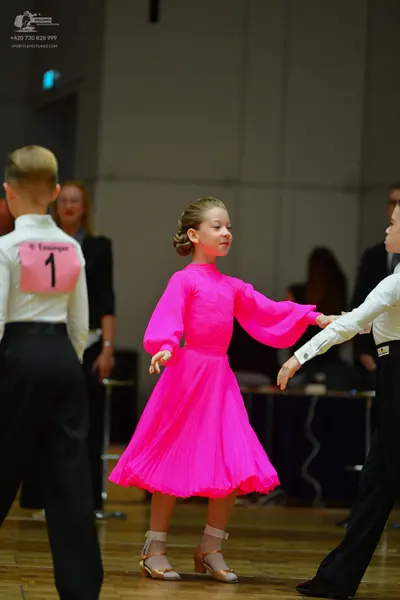 Dancesport competitor: Male dancer on left: white long-sleeved shirt and black trousers