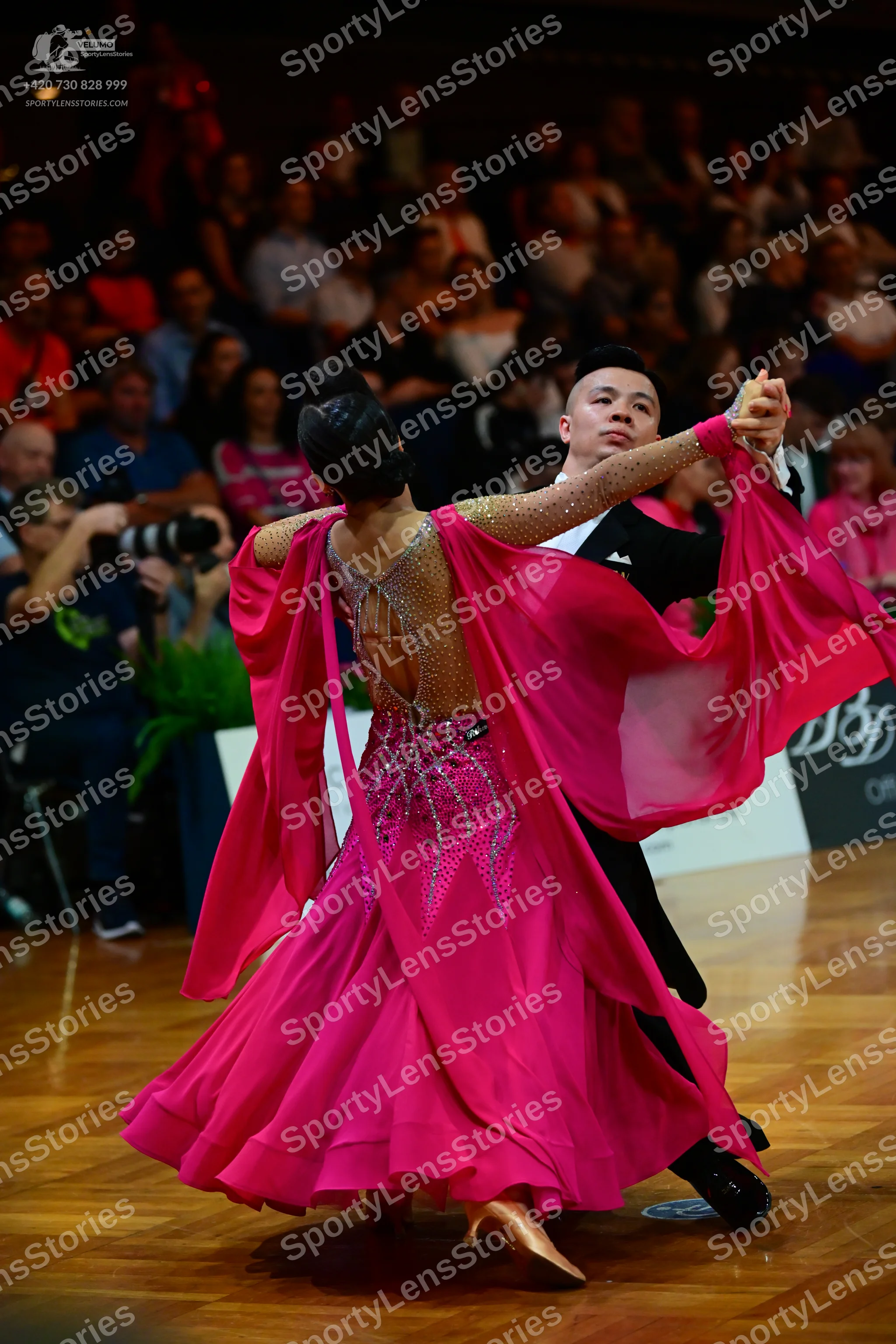 Dancesport competitor: Female dancer: vibrant pink ballroom dress with a heavily embellished gold/sequi