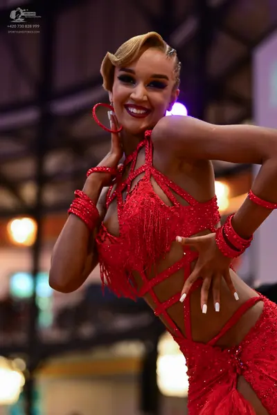 Dancesport competitor: Female dancer: red latin dress with sequins and fringe, including matching red a
