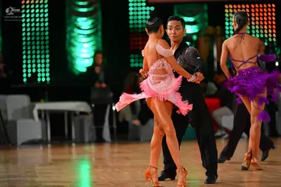 Dancesport competitor: Female dancer 1: light pink Latin dress with fringe and lace-like details