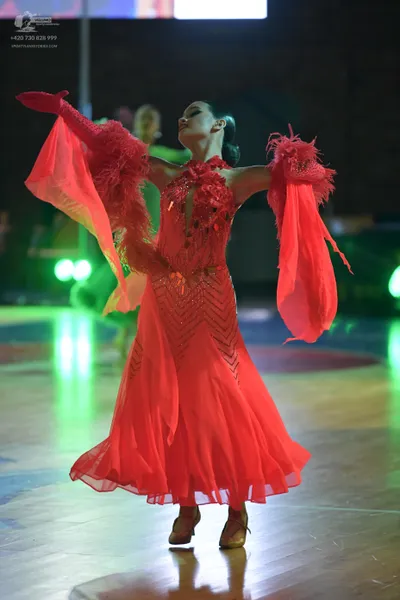 Dancesport competitor: Female dancer: red latin dress with sequin embellishments on the bodice, flowing