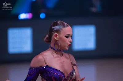 Dancesport competitor: Female dancer: purple latin dress heavily embellished with sequins and beads, fe