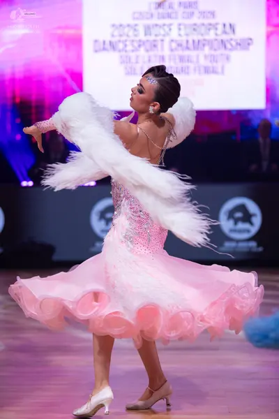 Dancesport competitor: Female dancer: light pink ballroom dress with sequins and a voluminous, ruffled 