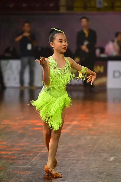 Dancesport competitor: Female dancer: bright lime green latin dress with lots of fringe