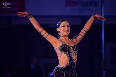 Dancesport competitor: Female dancer: black latin dress with sequins and crystals, featuring cutout sid