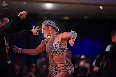 Dancesport competitor: Female dancer: champagne-colored Latin dance dress with large silver and white s