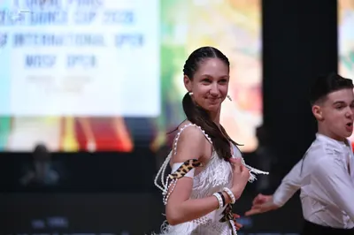 Dancesport competitor: Female dancer: white Latin dress with fringe and leopard print accents