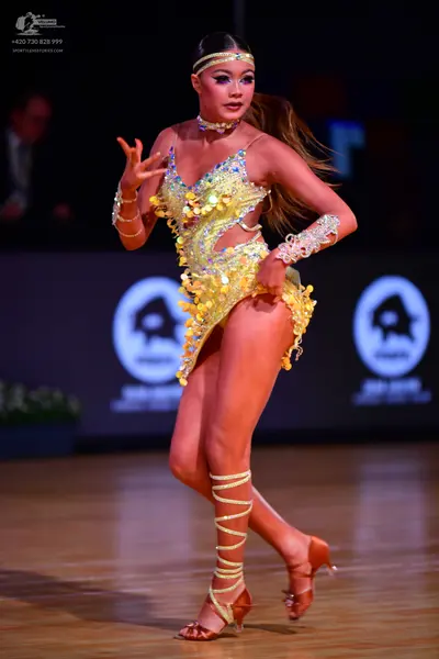 Dancesport competitor: Female dancer: yellow/gold sequined Latin dance dress with matching headband, ch