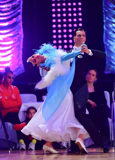 Dancesport competitor: Female dancer: white ballgown with a light blue bodice and voluminous white feat