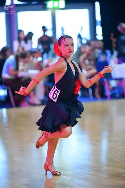Dancesport competitor #76: Female dancer: black latin dress with a flared, ruffled skirt and halter neck, a