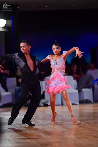 Dancesport competitor: Male dancer: black long-sleeved shirt with sequin embellishments on the chest an