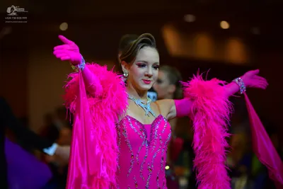 Dancesport competitor: Female dancer: bright pink Latin dance dress with silver sequin/rhinestone embel