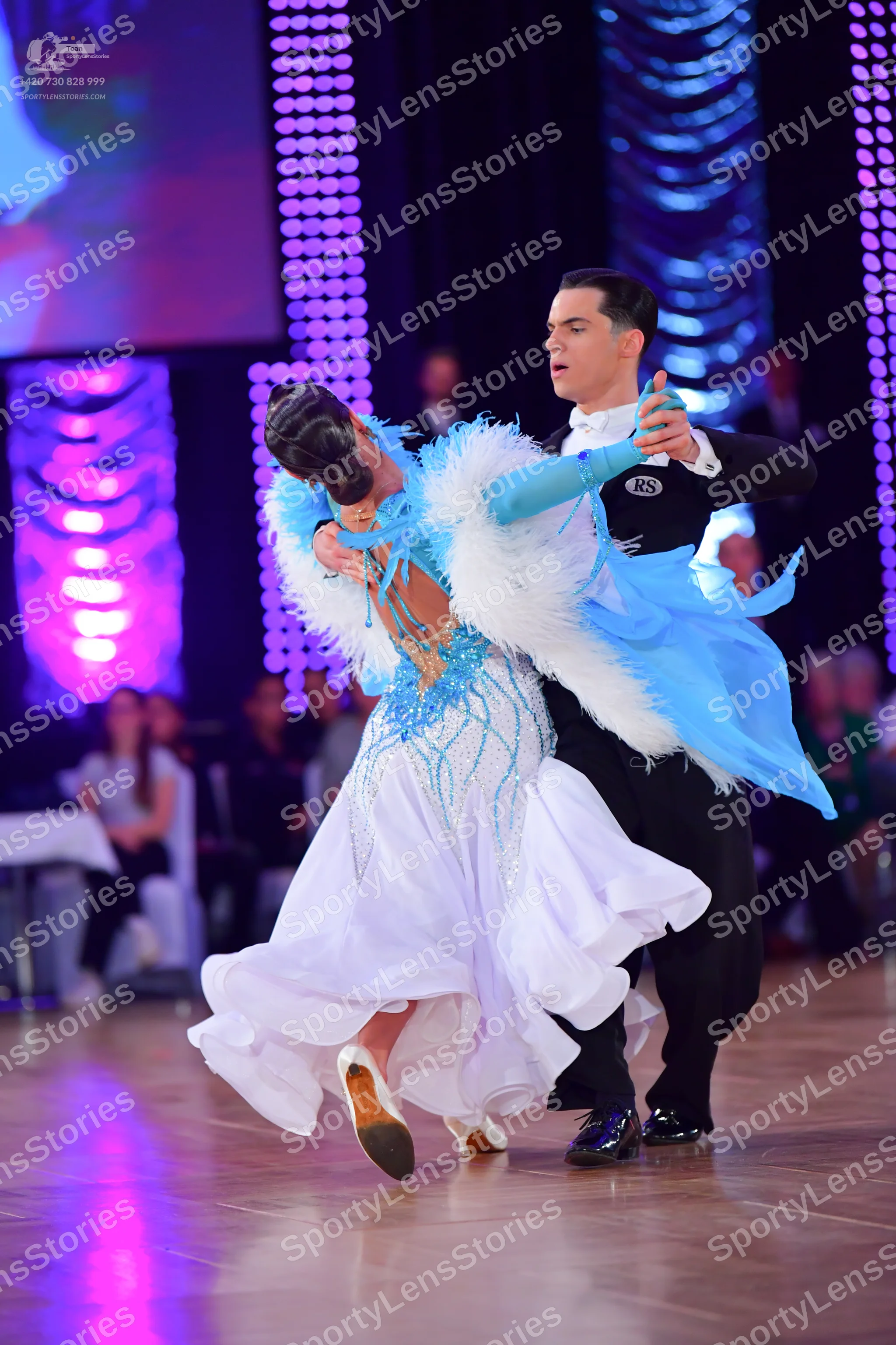 Dancesport competitor: Male dancer: black long-sleeved shirt with "RS" logo on the sleeve and black tro