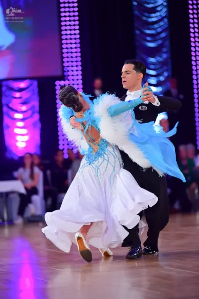 Dancesport competitor: Male dancer: black long-sleeved shirt with "RS" logo on the sleeve and black tro