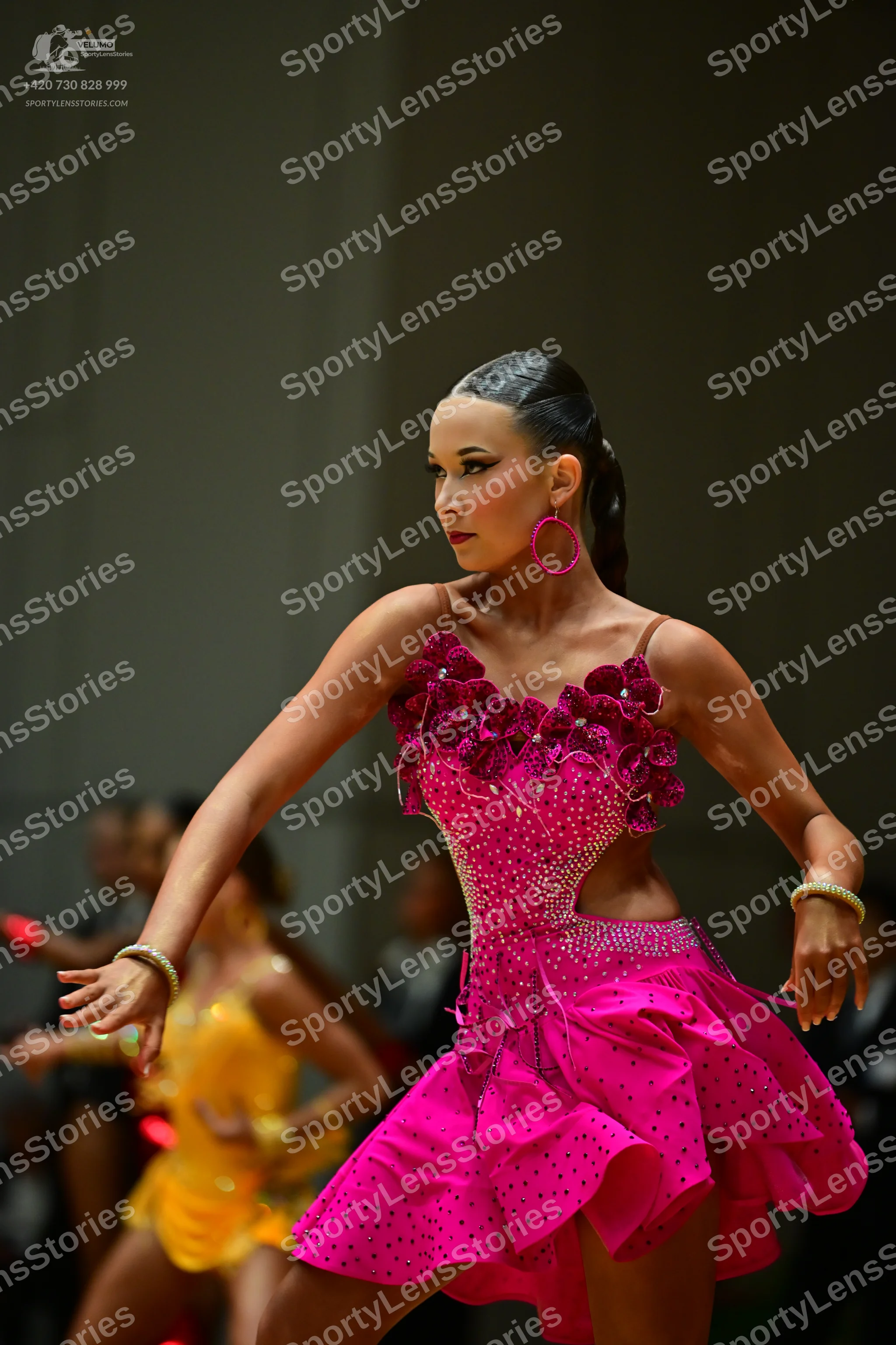 Dancesport competitor: Female dancer in foreground: bright pink latin dress with black rhinestones, 3D