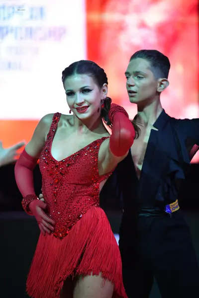 Dancesport competitor: Male dancer: black Latin dance shirt with ruffled layers and black trousers