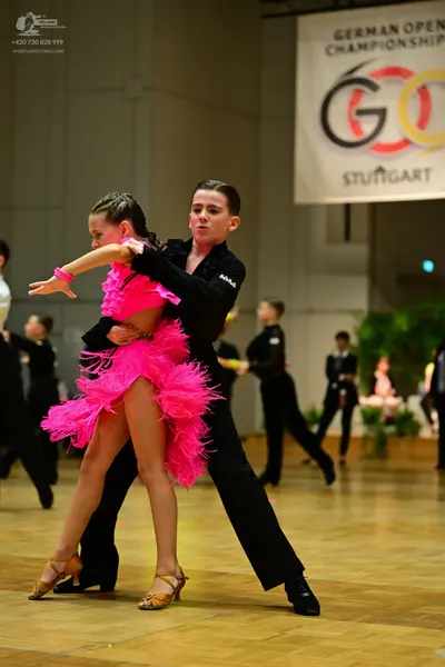 Dancesport competitor: Female dancer: bright pink Latin dress with a voluminous, fringed skirt