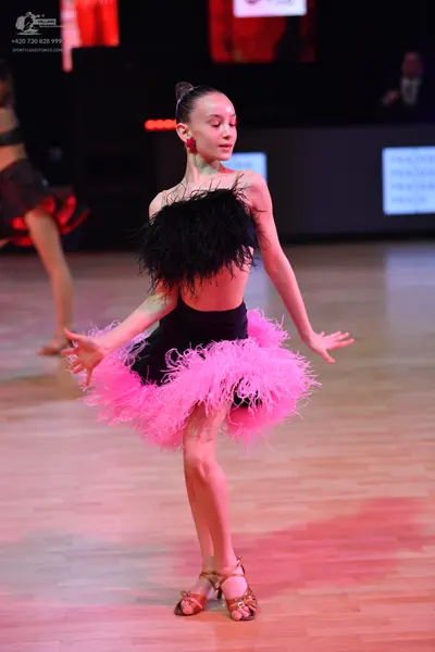 Dancesport competitor: Female dancer: black latin costume with black feathers on the bodice and a volum