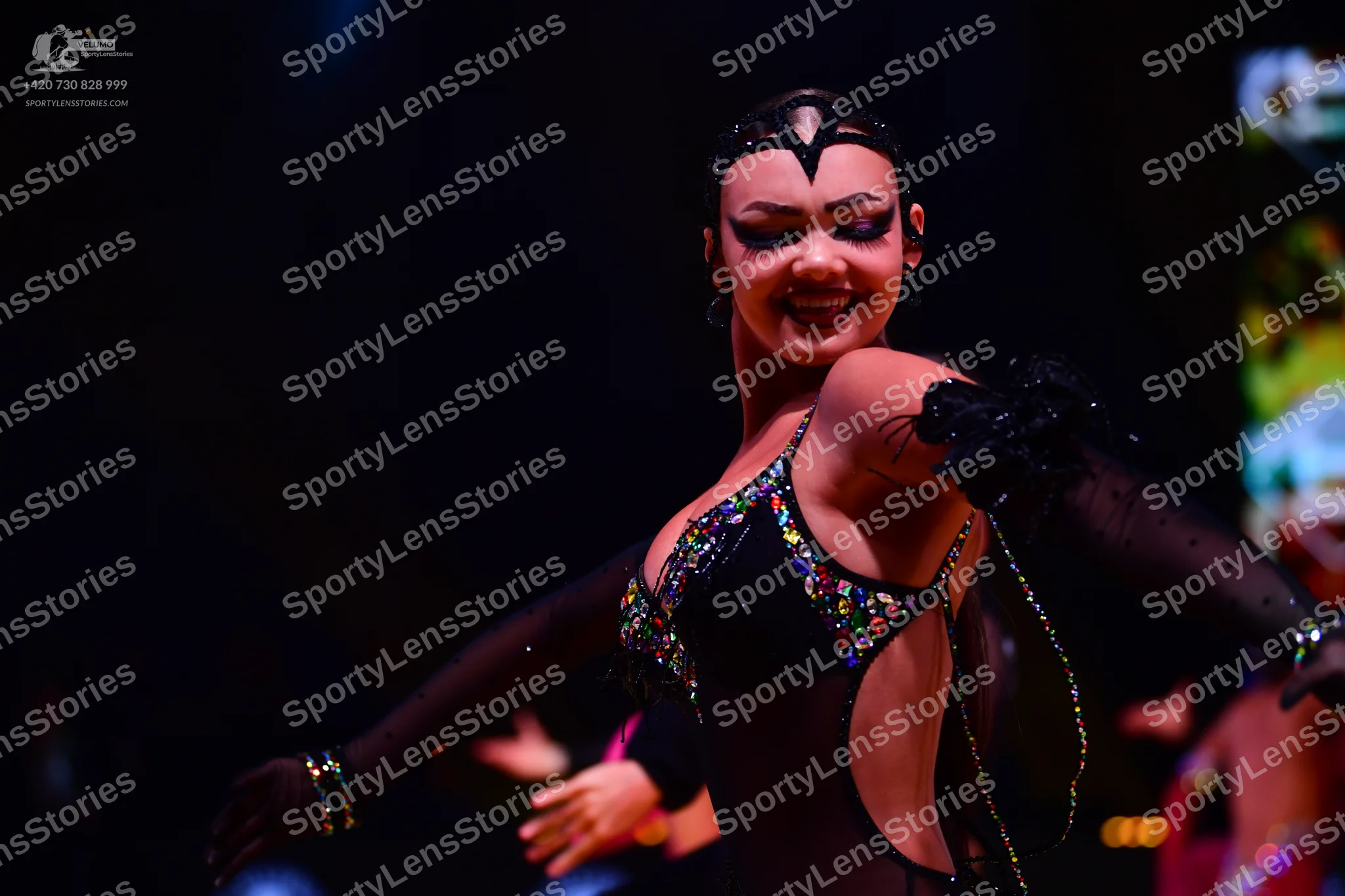 Dancesport competitor: Female dancer: black Latin dance costume with colorful sequins (gold, pink, gree
