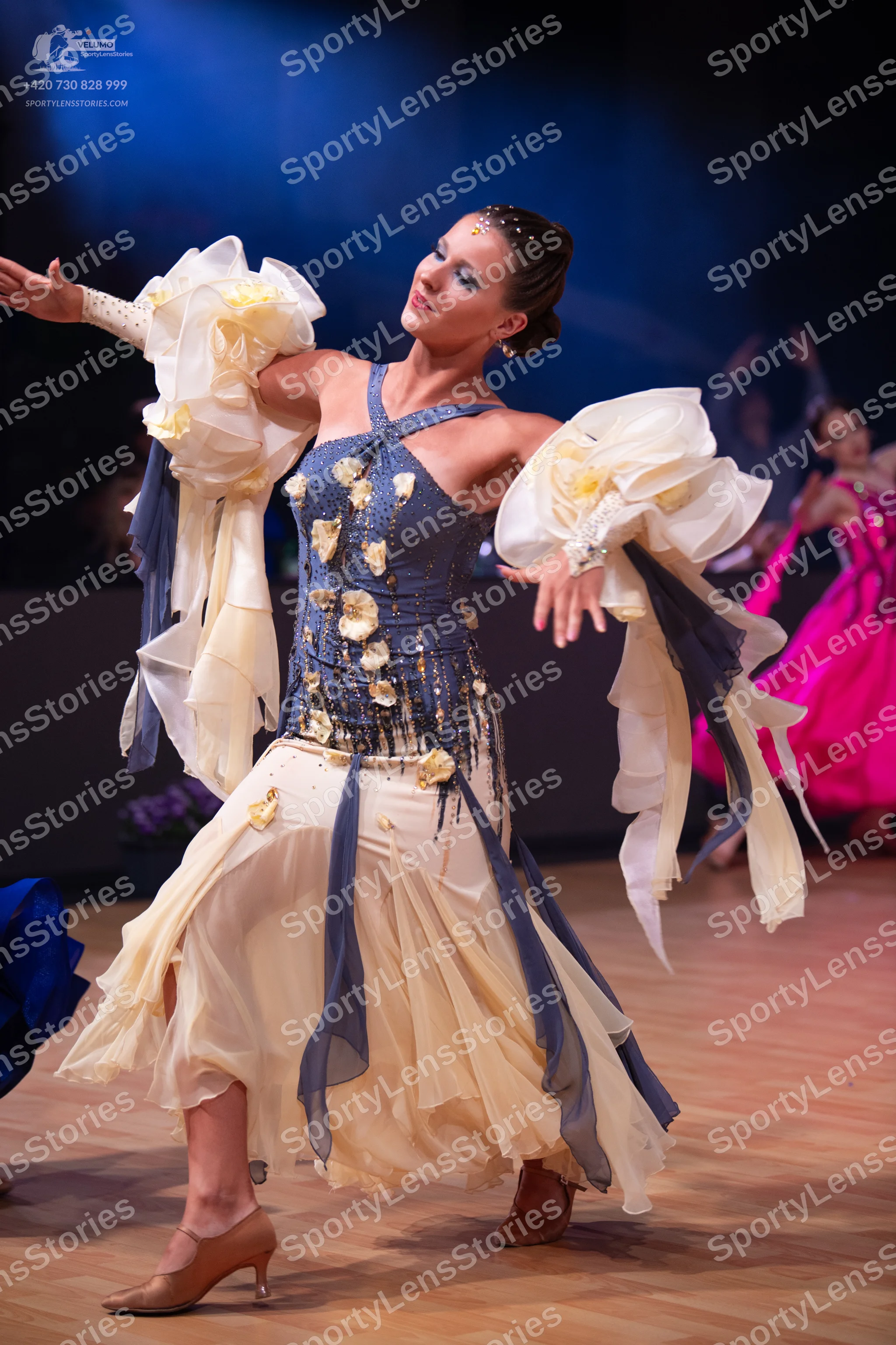 Dancesport competitor: Main female dancer: a latin dance dress featuring a navy blue/grey bodice decora