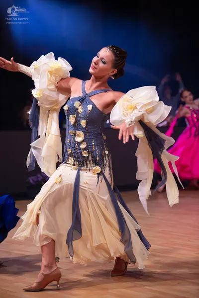 Dancesport competitor: Main female dancer: a latin dance dress featuring a navy blue/grey bodice decora