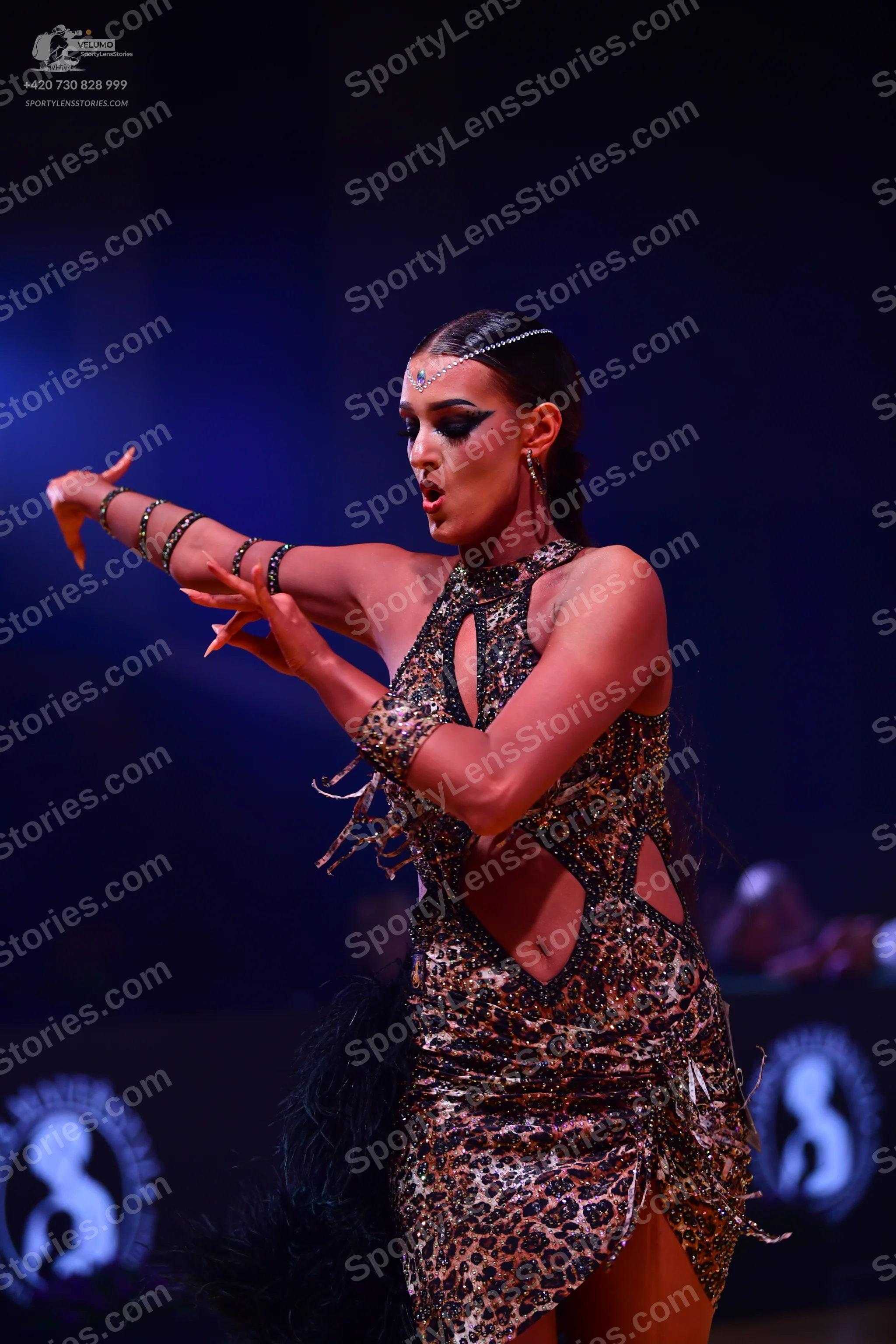 Dancesport competitor: Female dancer: leopard print latin dress with cutouts at the waist, featuring se