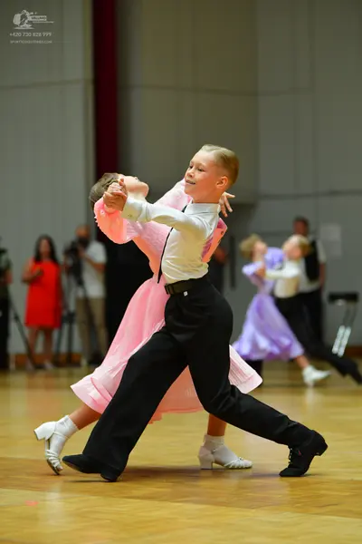 Dancesport competitor: Male dancer: white long-sleeved shirt, black trousers, and black dance shoes
