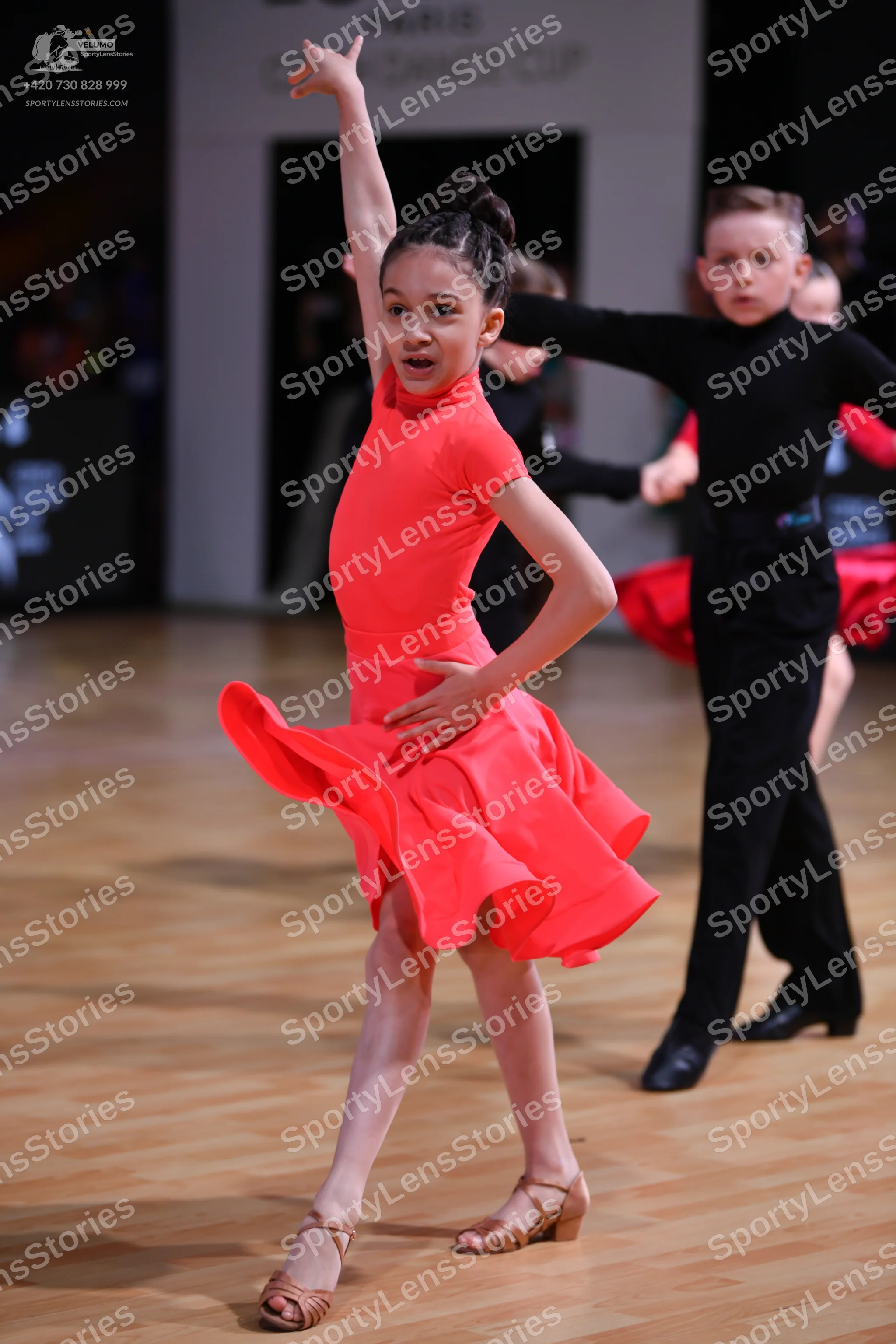Dancesport competitor: Female dancer: bright red latin dress with short sleeves and a flared skirt