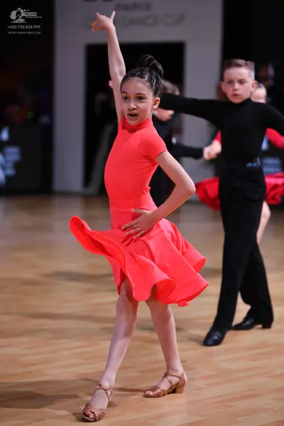Dancesport competitor: Female dancer: bright red latin dress with short sleeves and a flared skirt