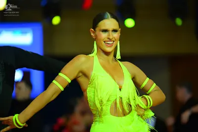 Dancesport competitor: Female dancer: lime green Latin dress with fringe and a deep V-neckline, includi