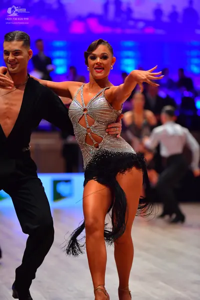 Dancesport competitor: Male dancer: black Latin dance top with a deep V-neck and black trousers