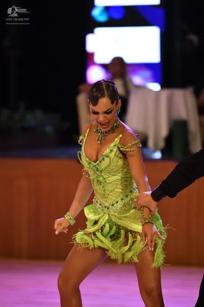 Dancesport competitor: Female dancer: lime green Latin dress with sequins, rhinestones, and fringe, acc