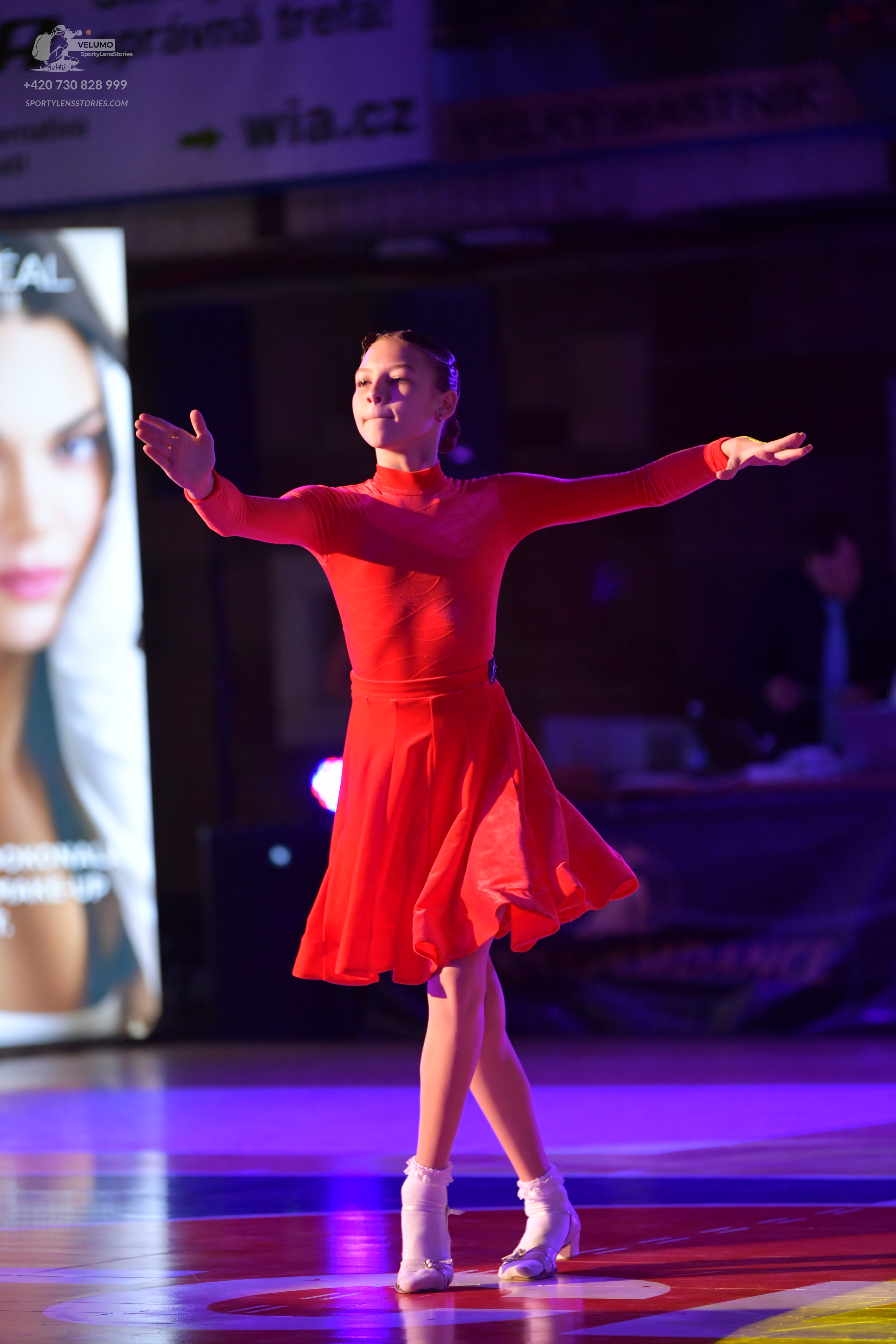 Dancesport competitor: Female dancer: red long-sleeved Latin dress with a flared skirt