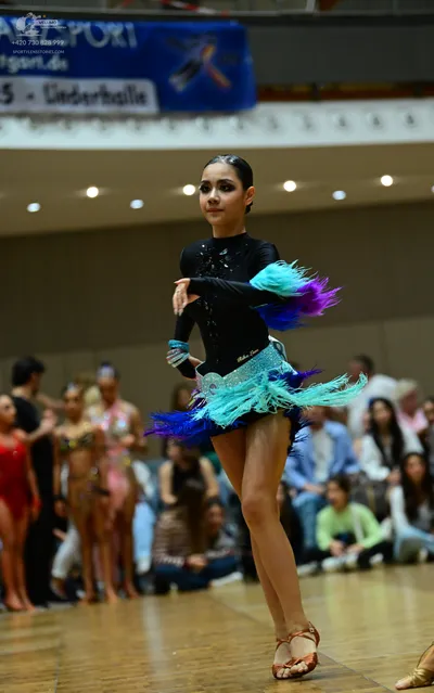 Dancesport competitor: Main female dancer: Black long-sleeved Latin dance top with a skirt made of vibr