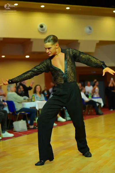 Dancesport competitor: Male dancer: black lace long-sleeved shirt with a deep V-neck and black trousers