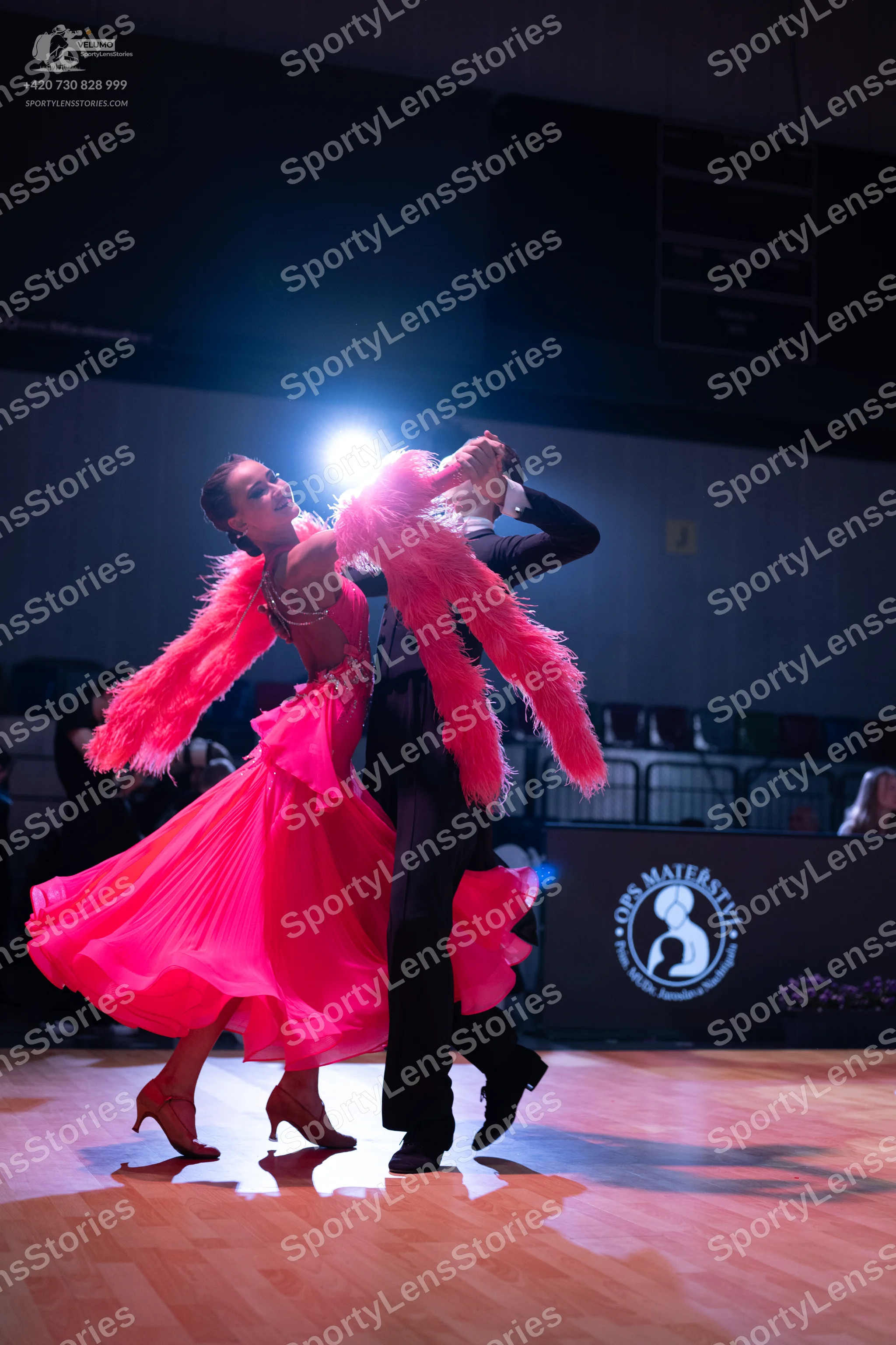 Dancesport competitor: Female dancer: bright pink ballroom dress with a full, flowing skirt and large,