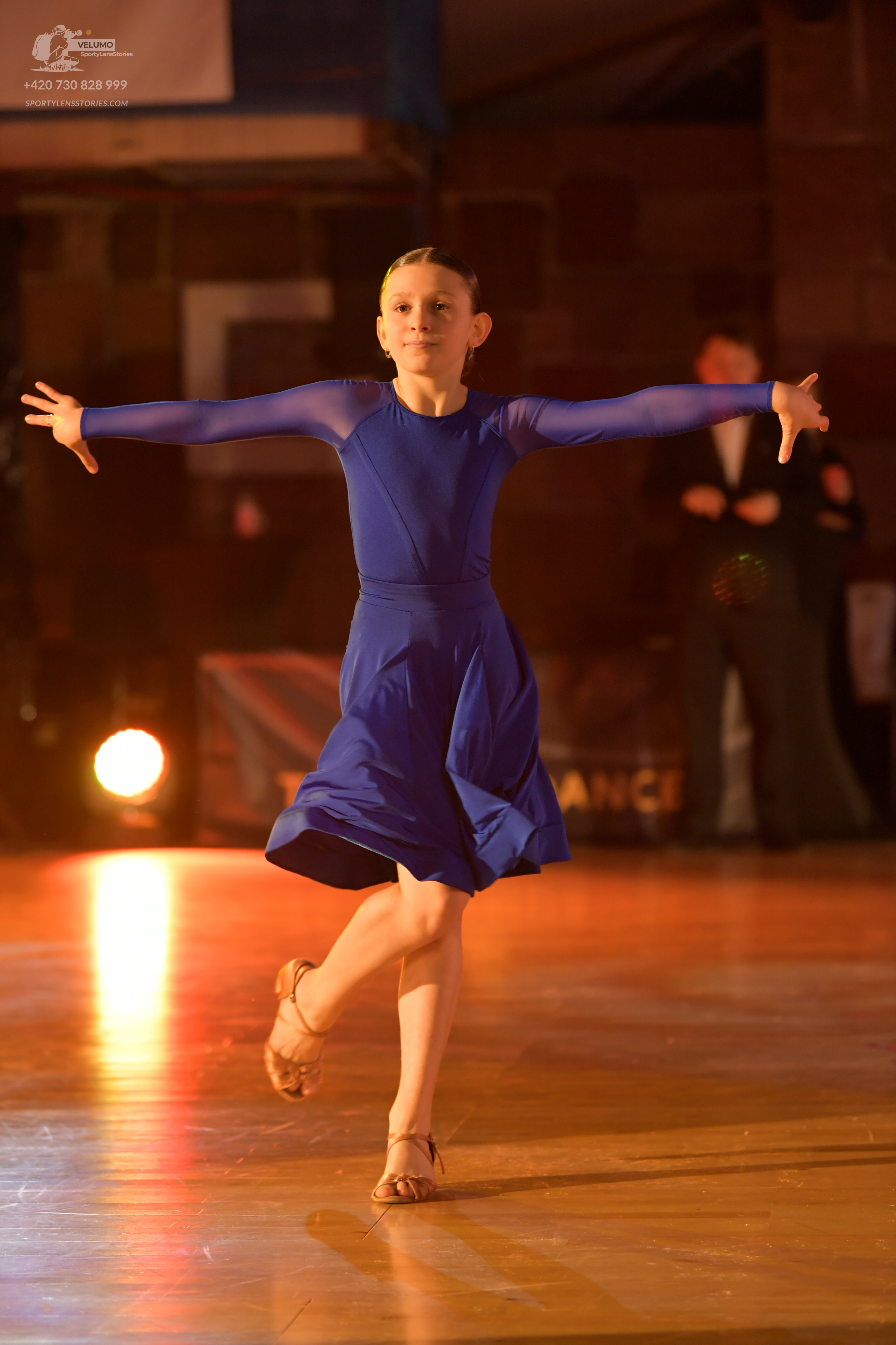Dancesport competitor: Female dancer: royal blue long-sleeved dance dress with a flowing skirt