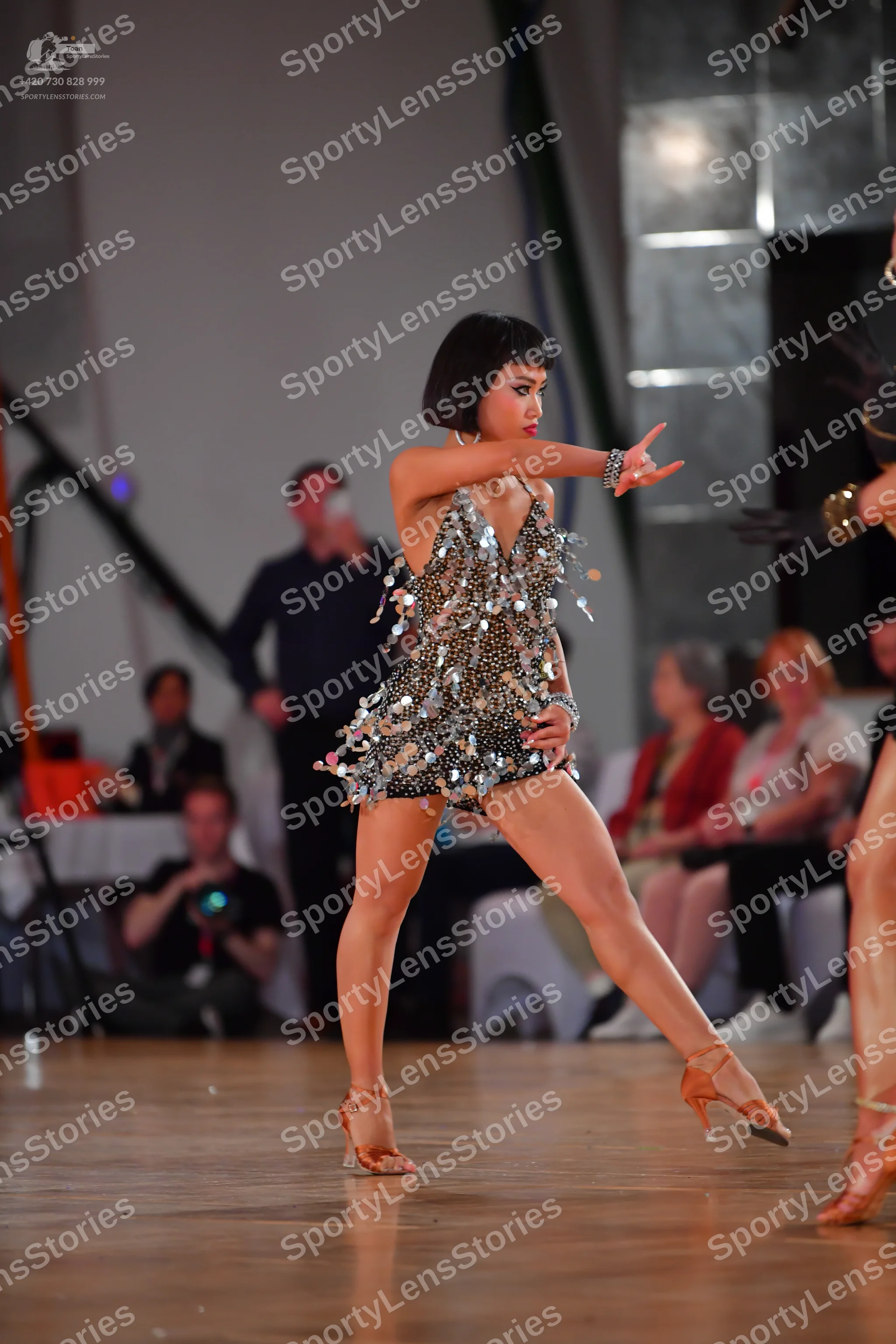Dancesport competitor: Female dancer: silver/metallic Latin dance costume featuring heavy sequin embell