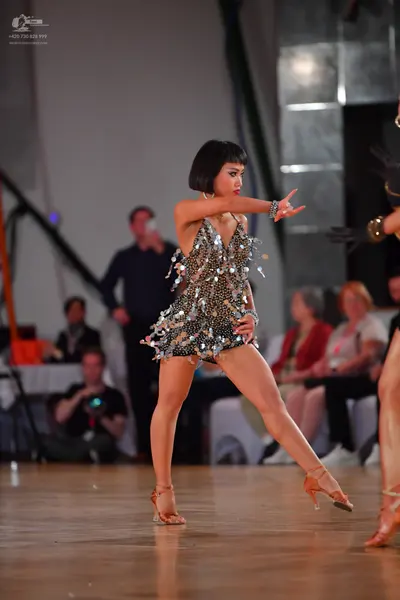 Dancesport competitor: Female dancer: silver/metallic Latin dance costume featuring heavy sequin embell