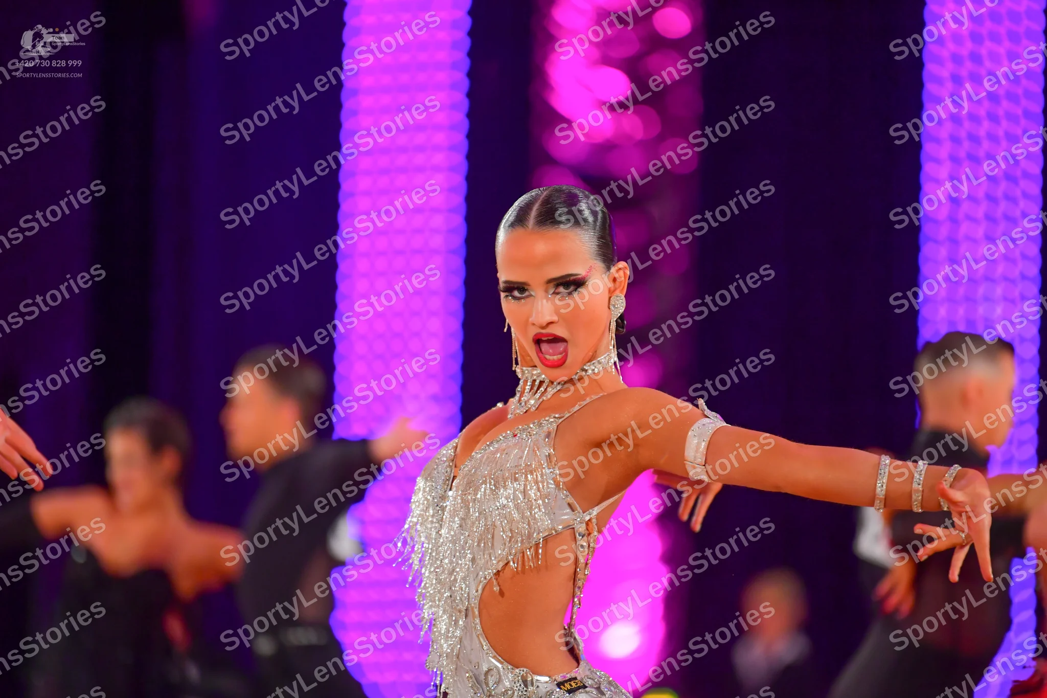 Dancesport competitor: Female dancer: silver Latin dress with sequins and fringe, featuring side cutout