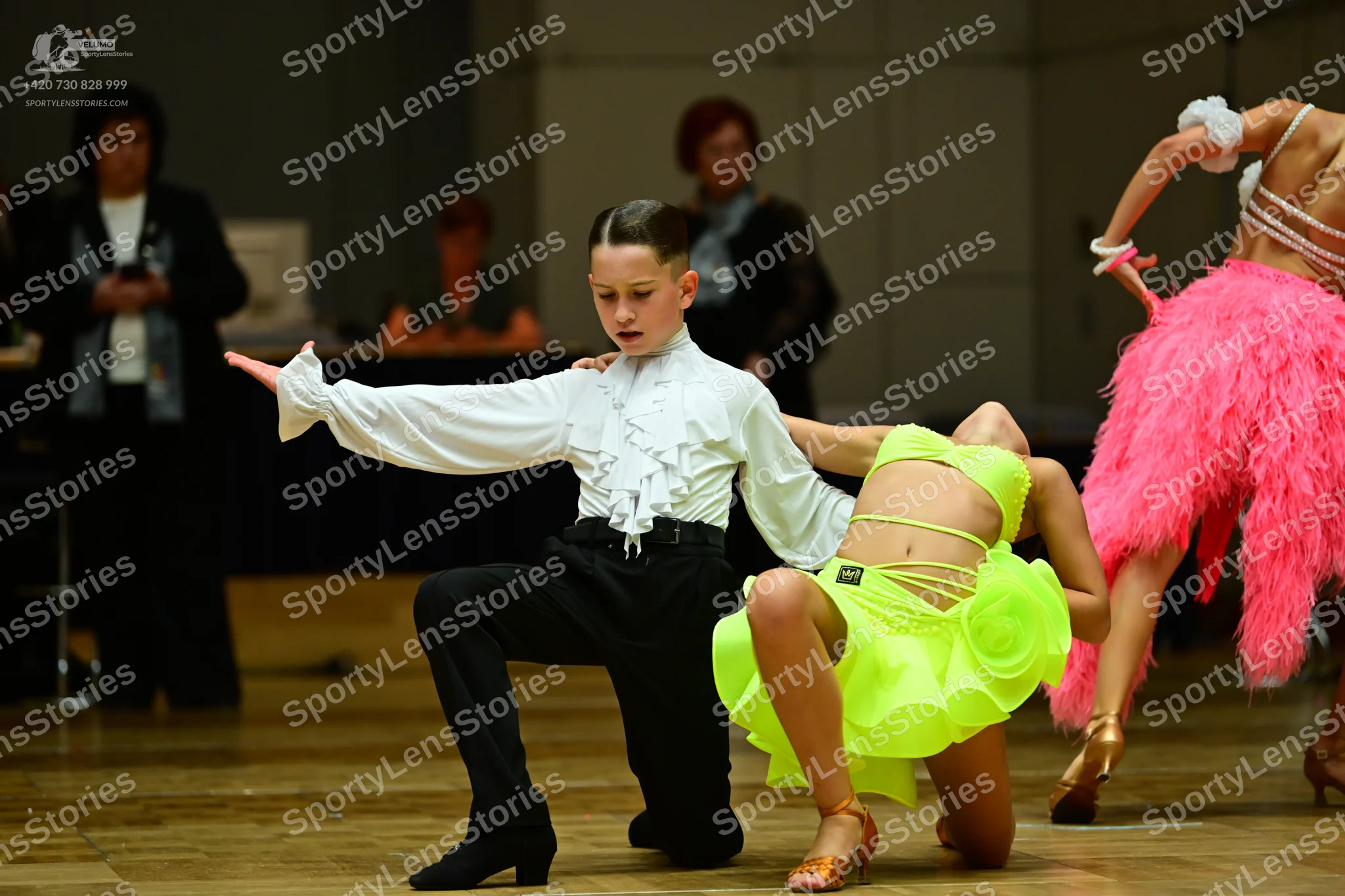Dancesport competitor: Male dancer: white long-sleeved shirt with ruffles on the front and cuffs, and b