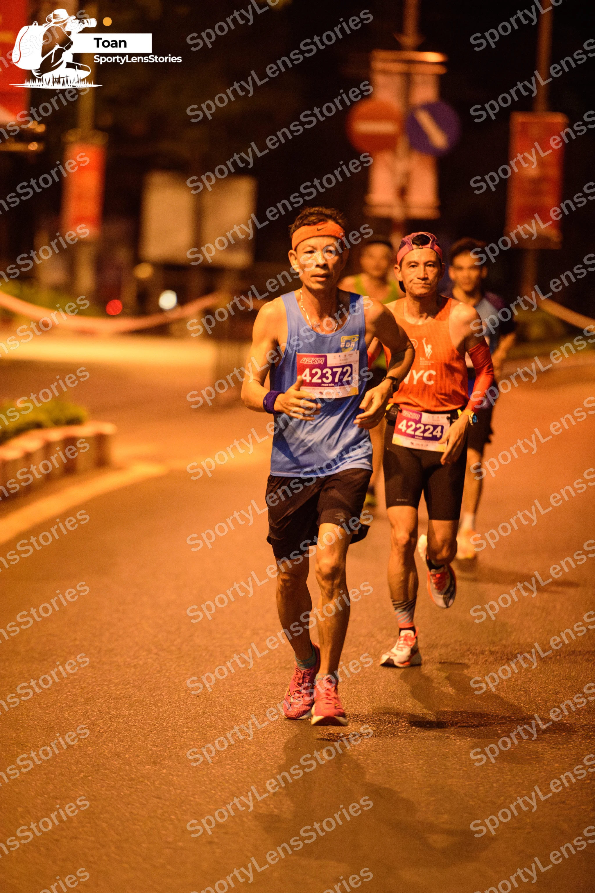 Marathon runner #42372, #42224: Runner 1: blue tank top, black shorts, pink shoes, orange headband, blue wristba