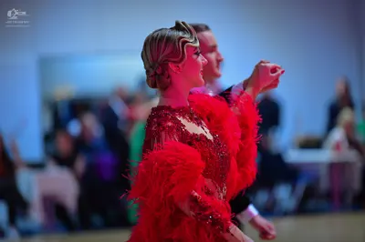 Dancesport competitor: Female dancer: red Latin dress with red feathers and red sequins