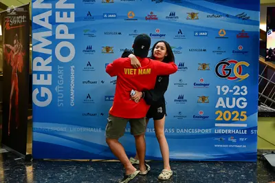 Dancesport competitor: Male dancer: red short-sleeved t-shirt with yellow "VIET NAM" text on the back a