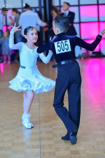 Dancesport competitor #505: Female dancer: white latin dress with long sleeves and a ruffled skirt