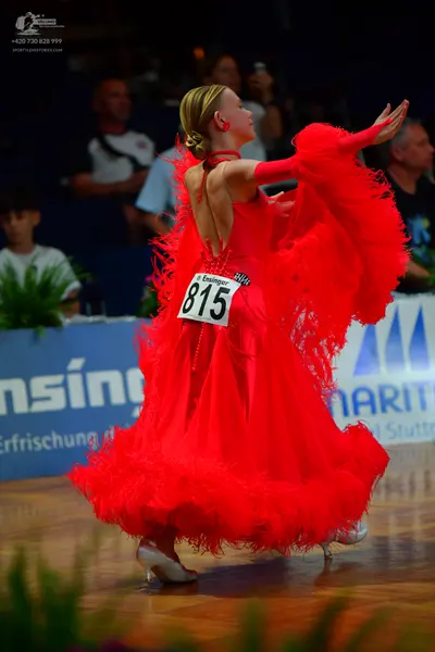 Dancesport competitor #815: Female dancer: red Latin dress with long red feathery fringe and red long gloves