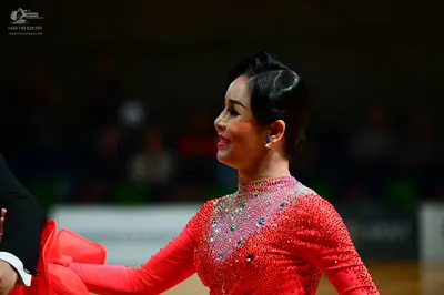 Dancesport competitor: Female dancer: red long-sleeved Latin dress with rhinestones on the bodice