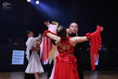 Dancesport competitor: Female dancer in red: red Latin dress with long, flowing, sheer red sleeves