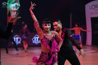 Dancesport competitor: Female dancer: magenta Latin dress with heavy fringe and rhinestone embellishmen